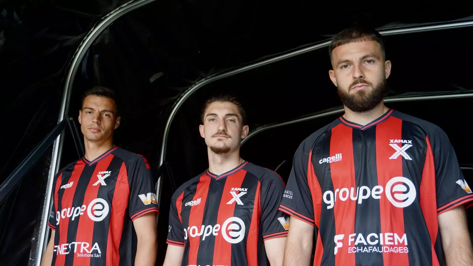 Neuchatel-assurances, Équipe de football fan de sport, joueurs avec maillot rouge et noir, équipe professionnelle, sportifs masculins, maillot de club, athlètes en action, partenariat sportif, équipement sportif, passion du football, compétition sportive, photographie d'équipe, promotion sportive, équipe de compétition, sport et assurance, identité visuelle sportive, fan de sportif, club de football, équipe sportive dynamique, jeu d'équipe, performance sportive.