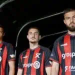 Neuchatel-assurances, Équipe de football fan de sport, joueurs avec maillot rouge et noir, équipe professionnelle, sportifs masculins, maillot de club, athlètes en action, partenariat sportif, équipement sportif, passion du football, compétition sportive, photographie d'équipe, promotion sportive, équipe de compétition, sport et assurance, identité visuelle sportive, fan de sportif, club de football, équipe sportive dynamique, jeu d'équipe, performance sportive.