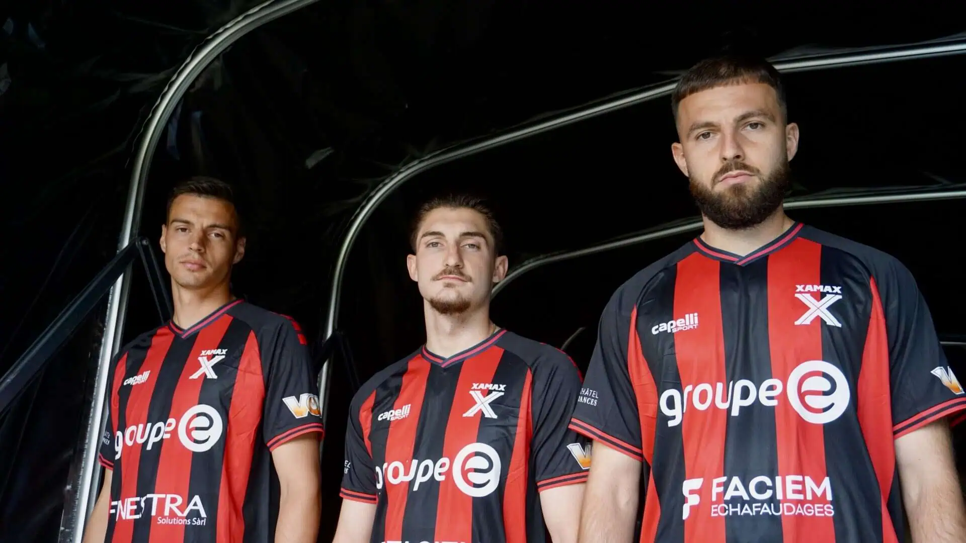 Neuchatel-assurances, Équipe de football fan de sport, joueurs avec maillot rouge et noir, équipe professionnelle, sportifs masculins, maillot de club, athlètes en action, partenariat sportif, équipement sportif, passion du football, compétition sportive, photographie d'équipe, promotion sportive, équipe de compétition, sport et assurance, identité visuelle sportive, fan de sportif, club de football, équipe sportive dynamique, jeu d'équipe, performance sportive.
