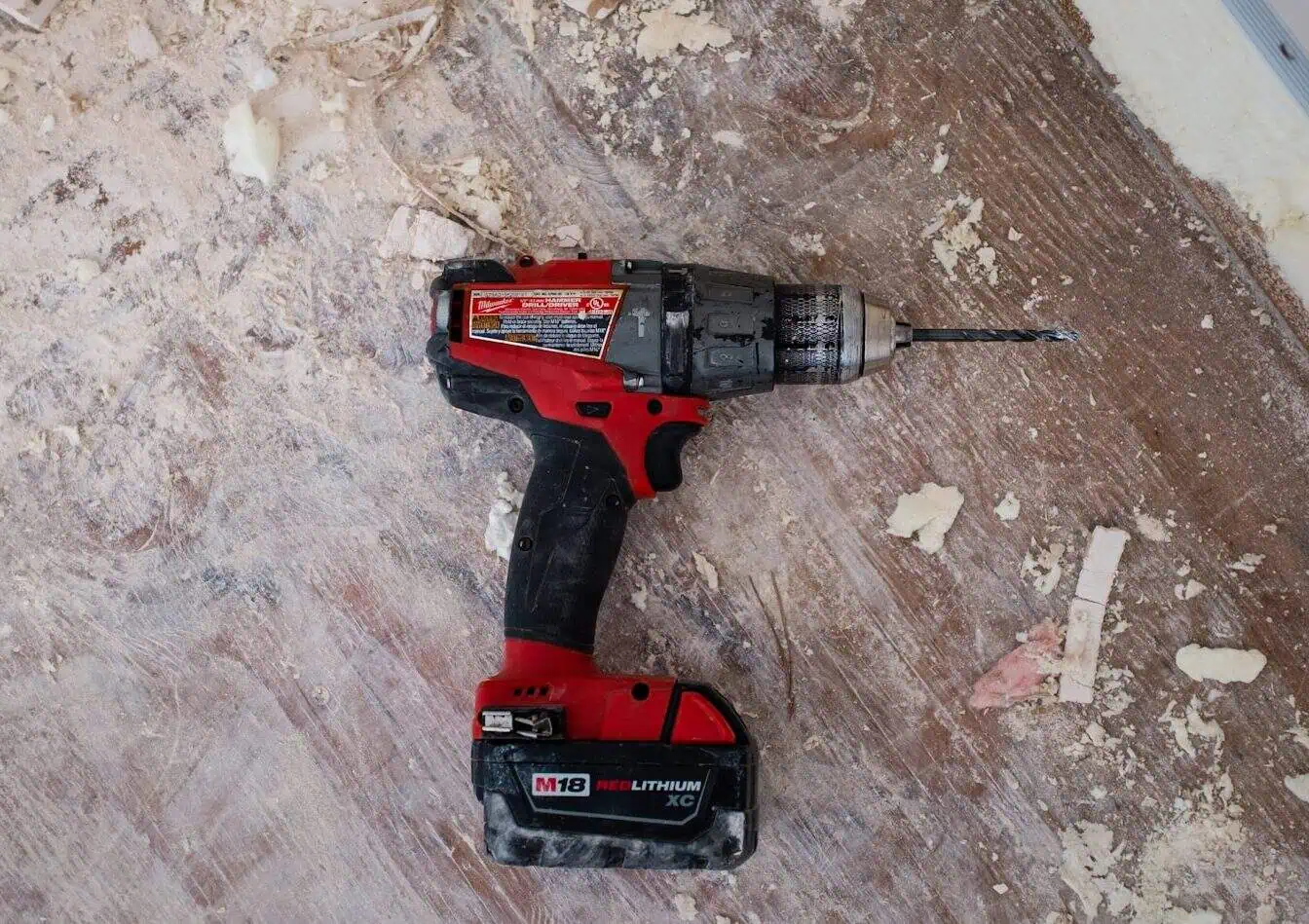 Perceuse sans fil Milwaukee M18 pour travaux de construction et rénovation, outil électrique puissant et résistant.