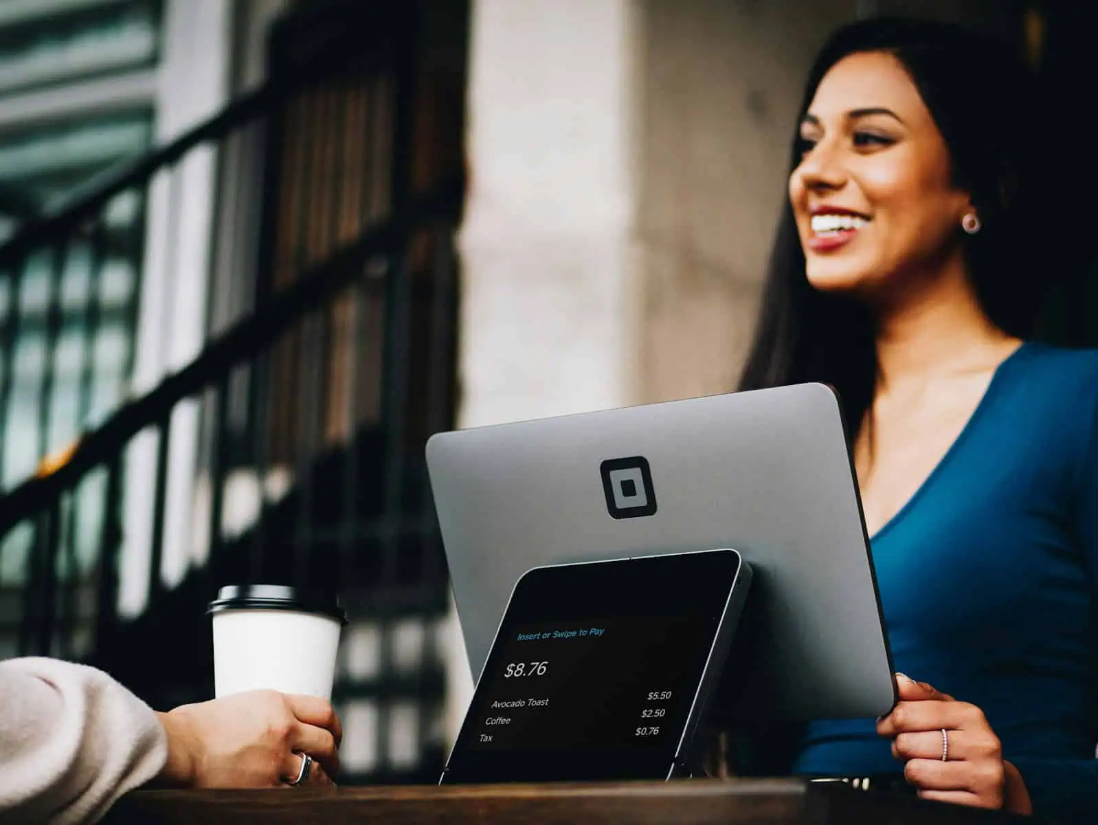Solution d'encaissement moderne avec terminal de paiement QR Code et ordinateur portable pour des transactions sécurisées. Service client efficace dans un environnement urbain dynamique.