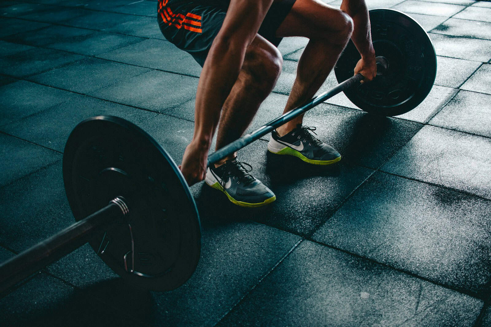 Barre de musculation avec haltères en salle de sport, entraînement fitness pour la tonification musculaire et la force physique. Image dynamique d'exercice sportif.