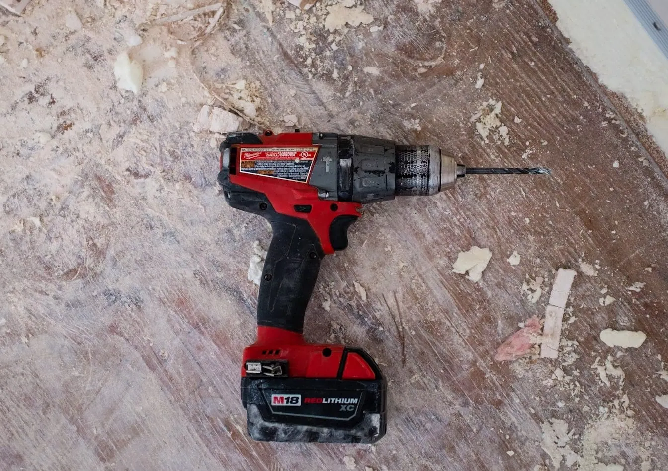 Perceuse sans fil Milwaukee M18 pour travaux de construction et rénovation, outil électrique puissant et résistant.