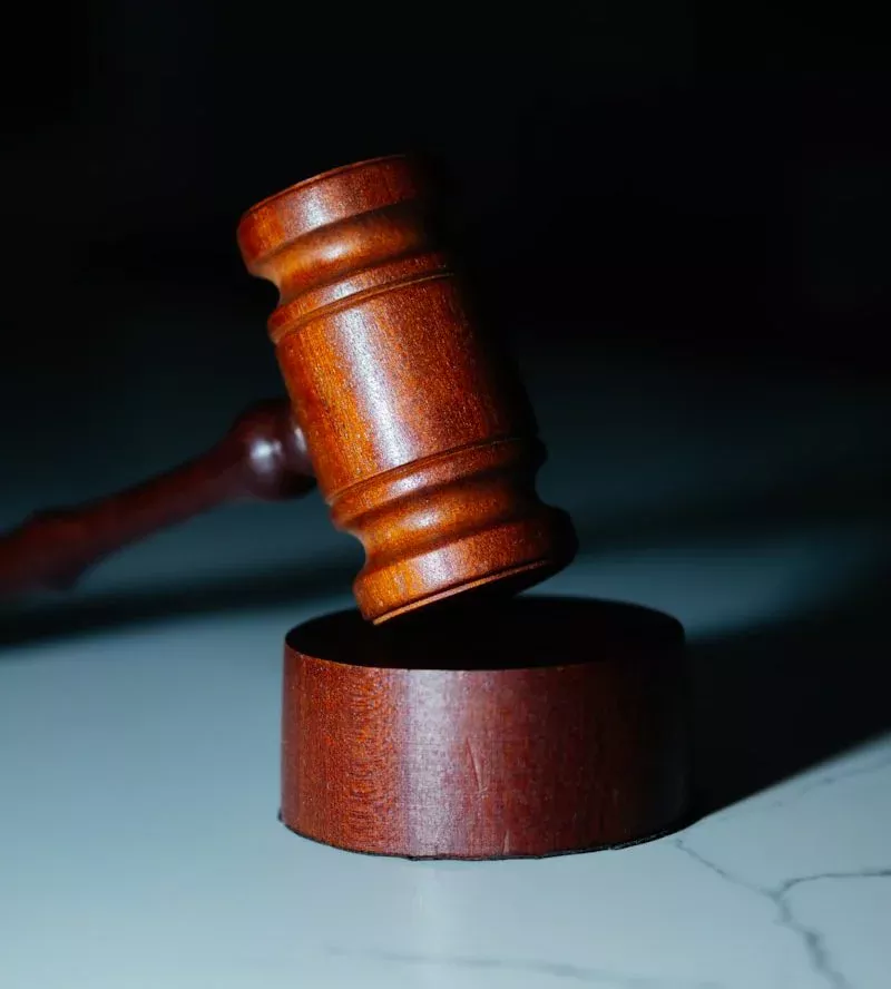 Saisi de marteau de juge en bois posé sur une table, symbole de justice et d'assurance légale, mettant en valeur la conformité et la fiabilité dans le domaine des assurances à Neuchâtel.